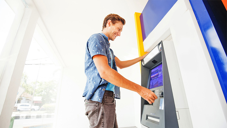 Man standing at an atm